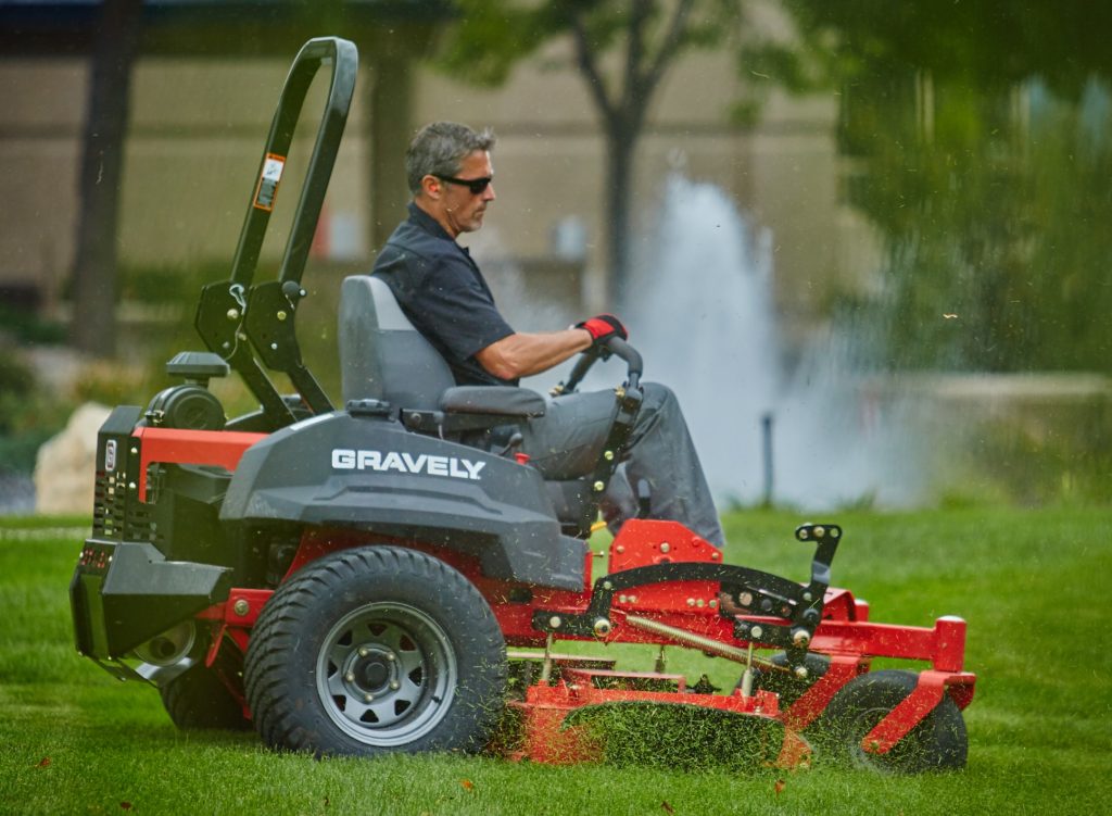 Showing gravely commercial lawn mower pro-turn zero turn rider cutting grass by landscaper Abco Truck Equipment Toledo Ohio and Michigan