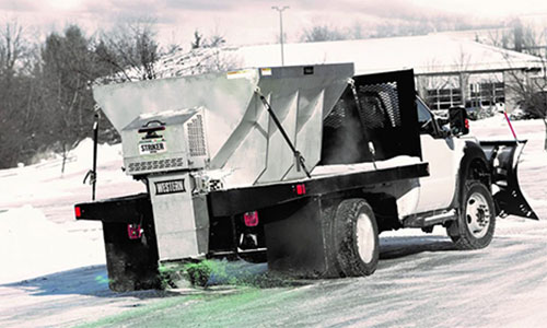 Showing western snowplows v-box salt spreader applying salt during snow storm installed on snowtruck; Abco truck equipment Toledo Ohio and Michigan
